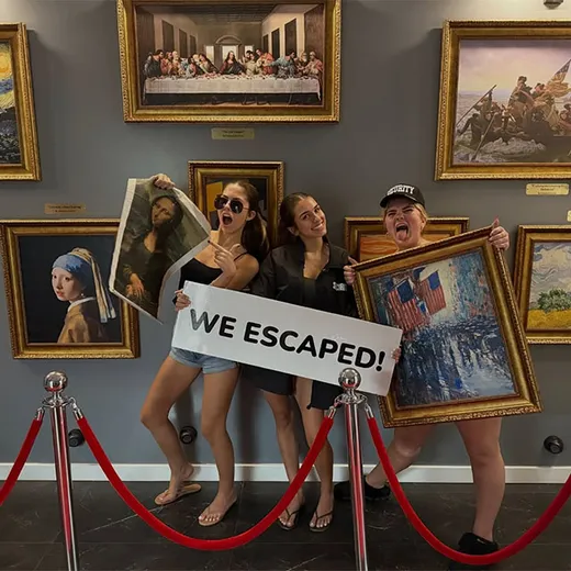 Escape room guests holding a We Escaped sign