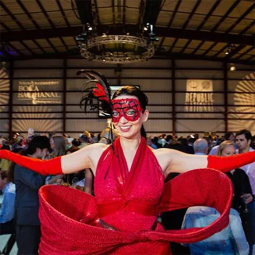 Performer in a red costume and mask at a hangar event